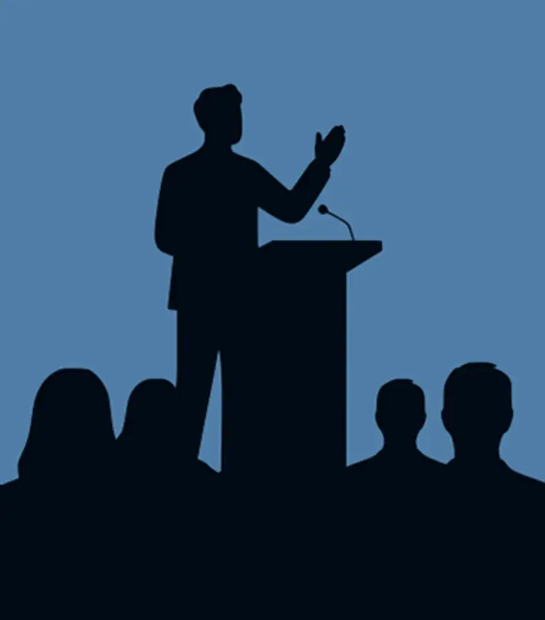 conferencier-devant-un-public Orateur debout s’adressant à un public – illustration d’un discours en situation
